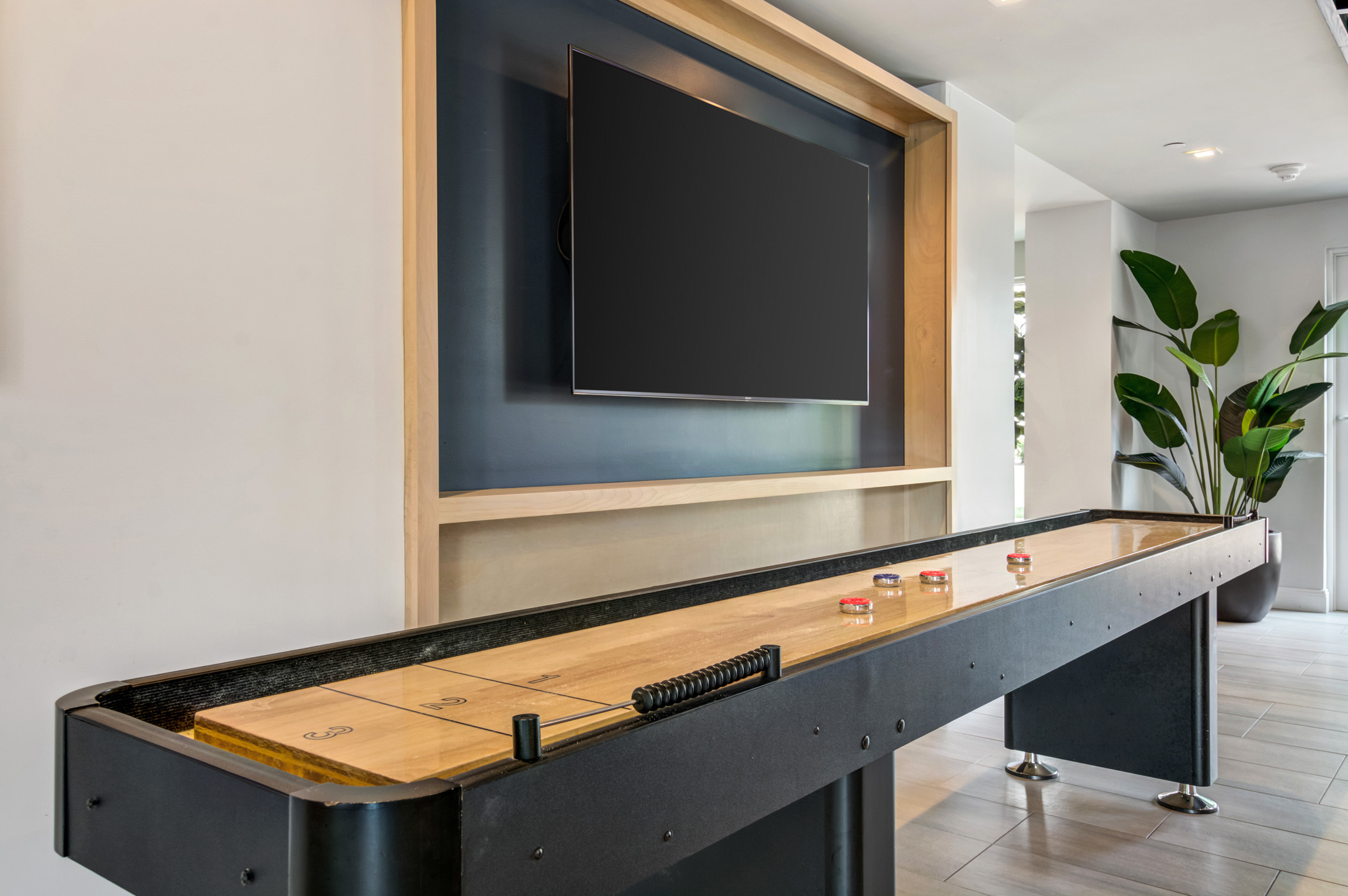 shuffleboard table with large tv overhead